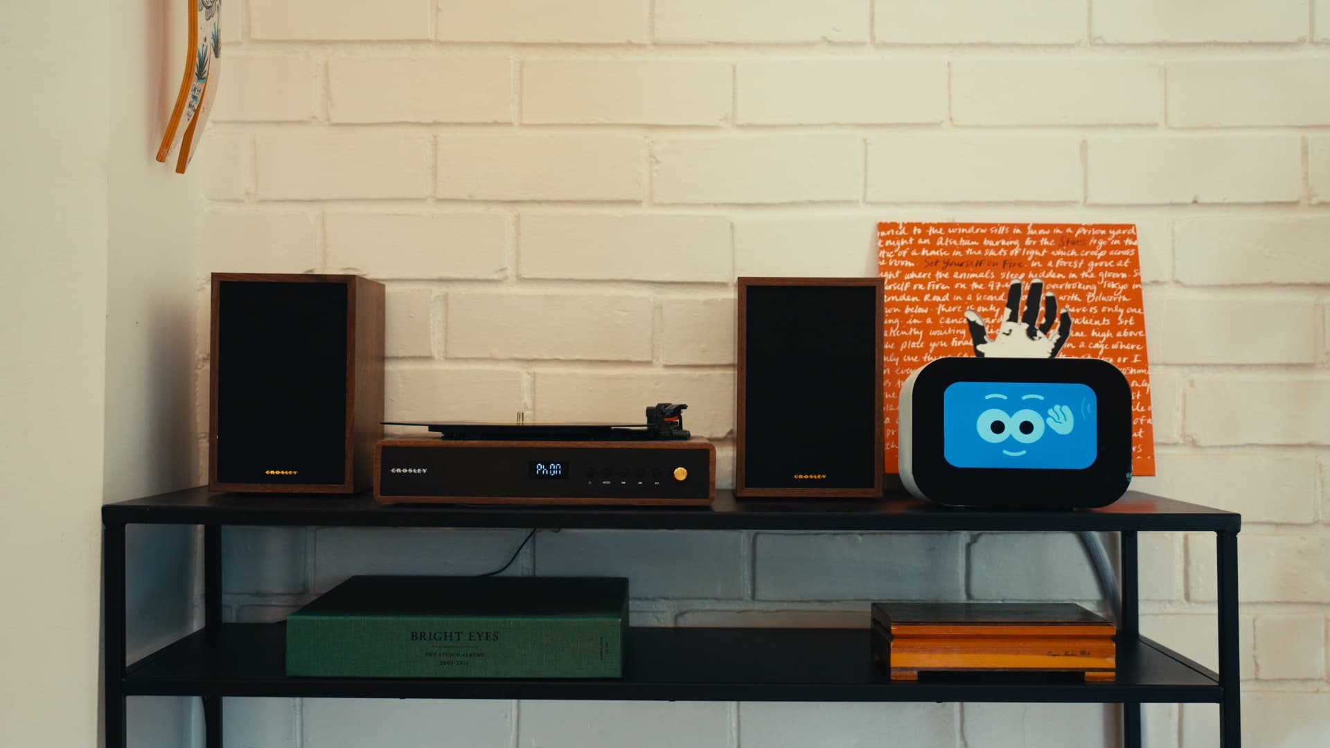 Rhem home robot on a shelf with a record player in a cozy living room.