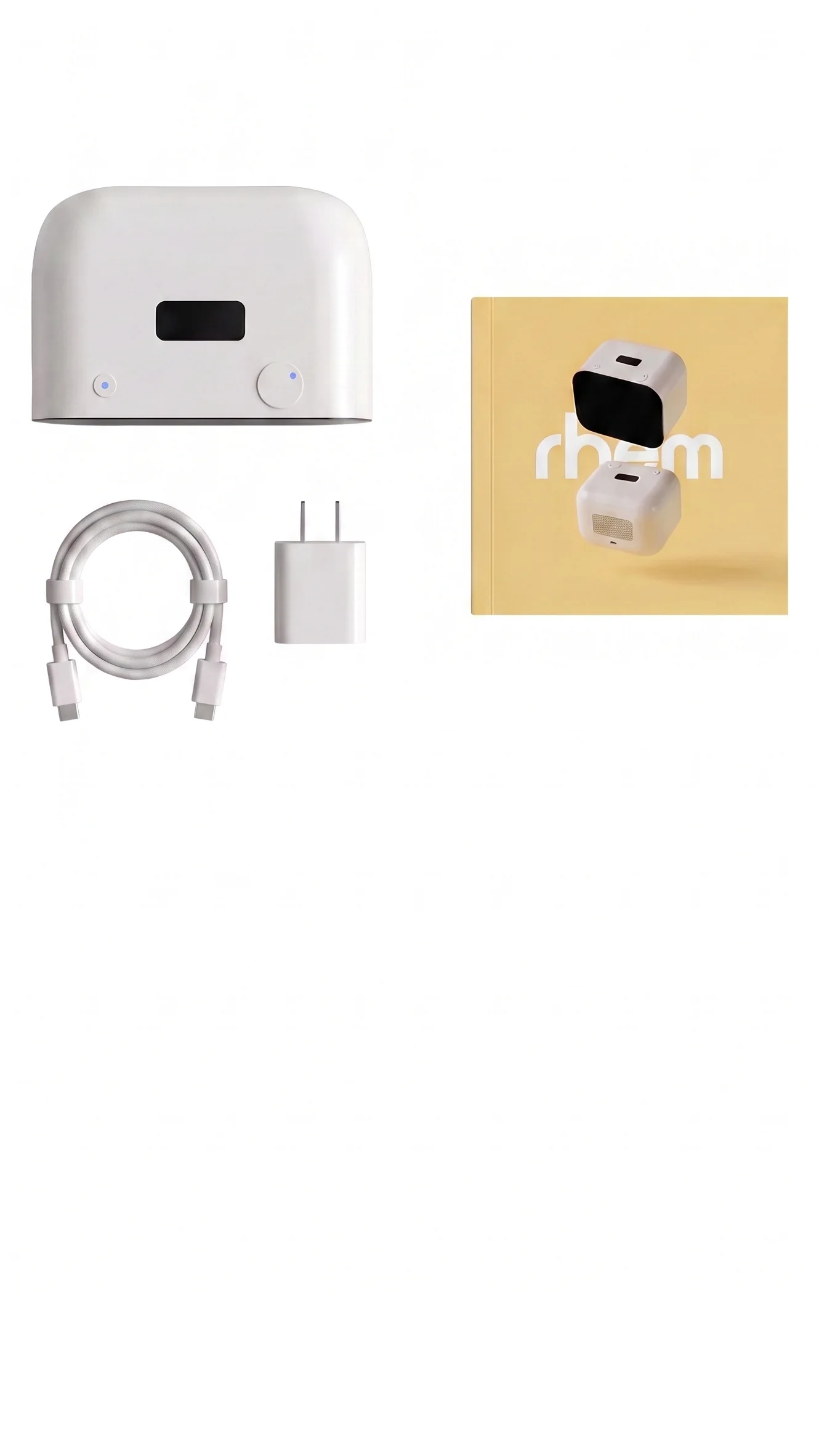Overhead view of the box contents: the Rhem robot, a USB-C cable, a charging brick, and the user manual